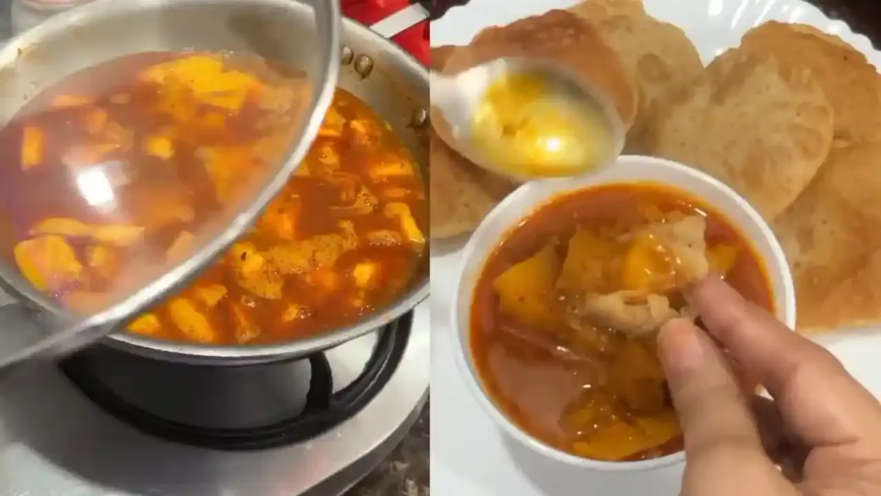 पारंपारिक आम की खट्टी मीठी सब्जी स्टीलच्या कढईत उकळत आणि फुलकी सोनेरी पुरीसोबत सर्व्ह केली जाते.