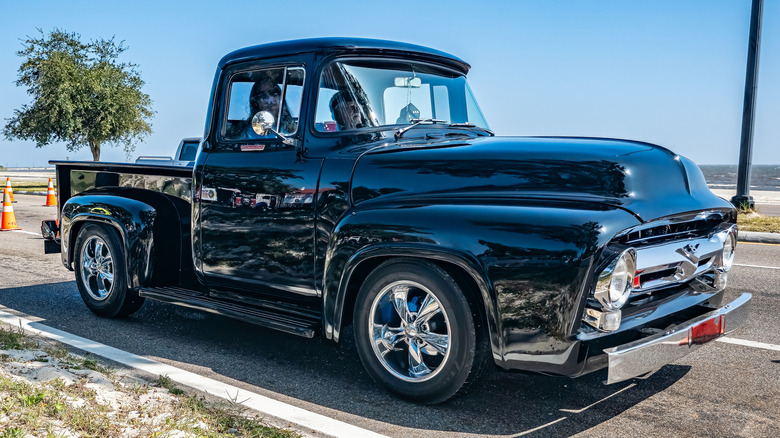 रस्त्याच्या कडेला उभी असलेली काळी 1956 फोर्ड F100