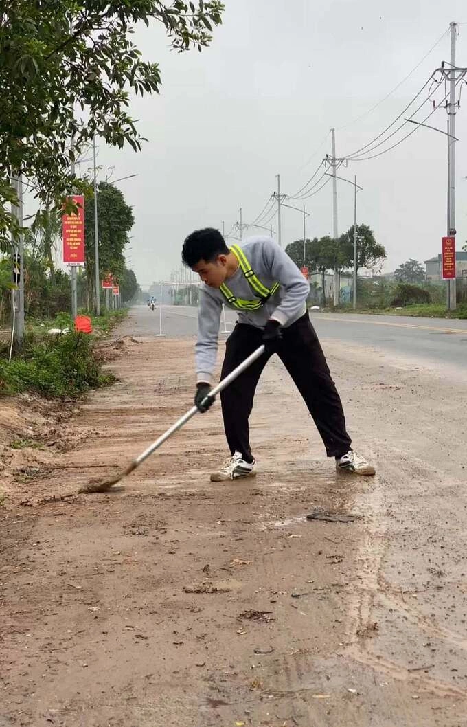 Vu Duy Nhat गवत कापत आहे आणि 23 फेब्रुवारी रोजी हनोईच्या बाहेरील कम्युनमध्ये गवत आणि चिखलाने अतिक्रमण केलेला रस्ता साफ करत आहे. फोटो: पात्राद्वारे प्रदान केलेला