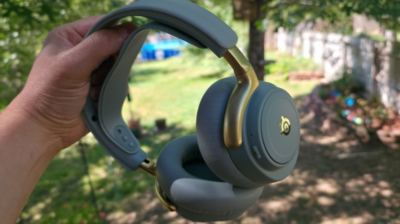 Arctis Nova Elite हेडसेट धरलेला हात