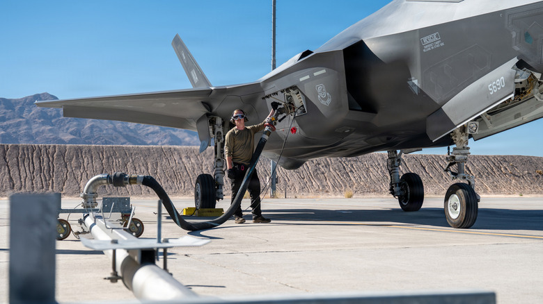 युनायटेड स्टेट्स एअर फोर्स ग्राउंड क्रू मेंबर F-35 जेट फायटरमध्ये इंधन भरत आहे.