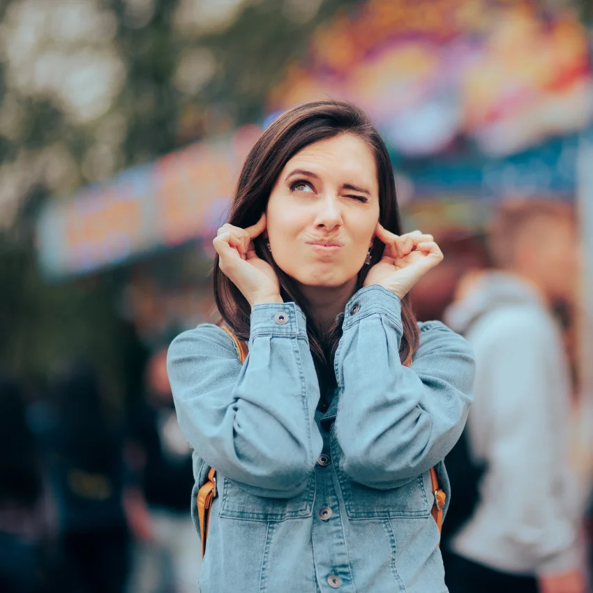 मोठ्या आवाजात भरलेल्या मैफिलीच्या ठिकाणी कान ओढत असलेली empath बाई