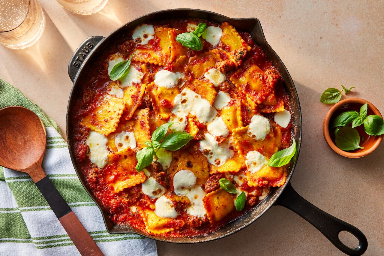 Skillet Ravioli Lasagna चा फोटो तुळशीने सजलेला आणि सर्व्ह करण्यासाठी तयार आहे श्रेय: छायाचित्रकार: केल्सी हॅन्सन, फूड स्टायलिस्ट: हॉली ड्रेसमन, प्रॉप स्टायलिस्ट: ब्रेना गजाली